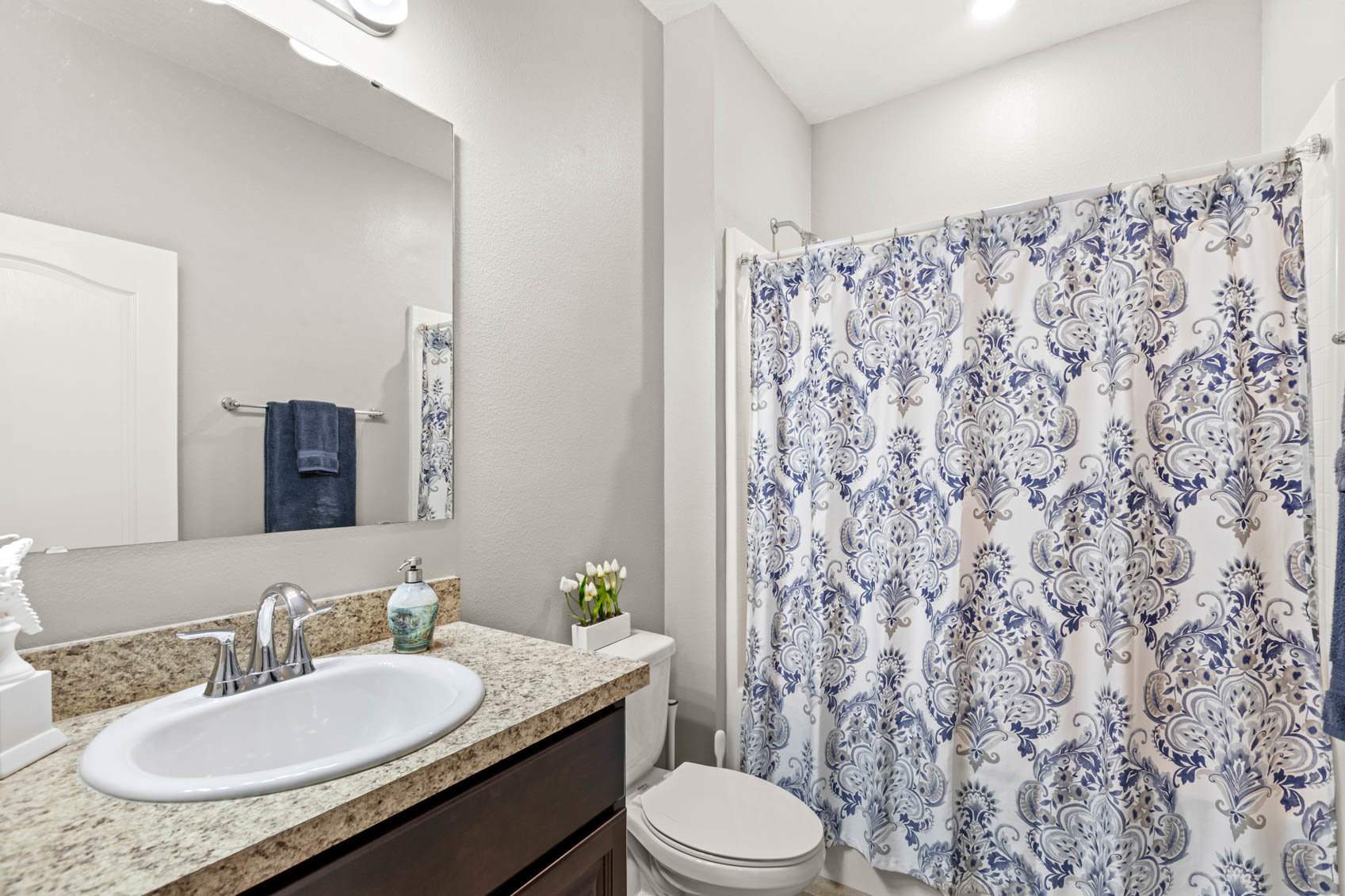 bathroom with blue and white shower curtain